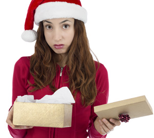 Girl in Christmas costume unhappy looking at a box