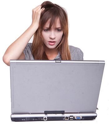 Girl scratching her head in front of computer